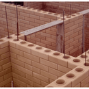Top view of an eco-friendly brick wall under construction, showcasing hollow bricks and reinforcement bars.